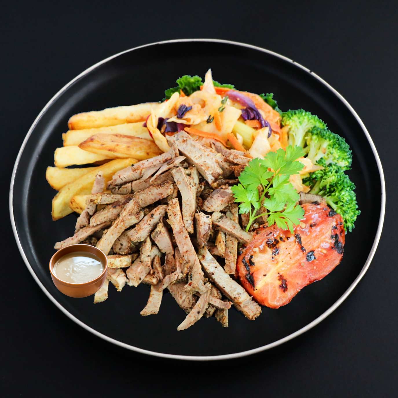 A plate of a Gourmet beef shawarma with roasted potato fries and tahini on the side, garnished with fresh parsley.