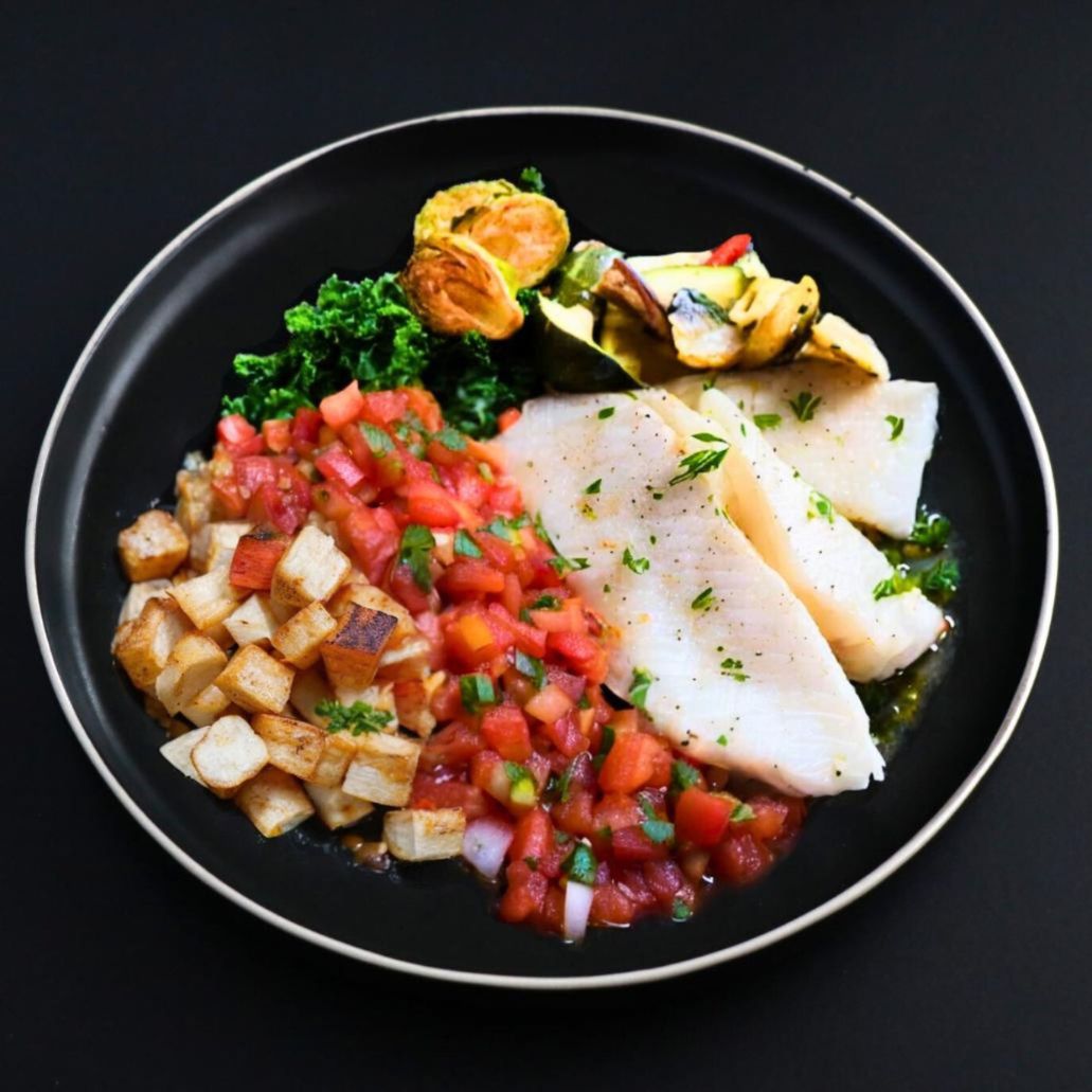 A plate containing grilled cod fillet topped with bruschetta, roasted taro root, and seasoned with tomato, basil, and parsley.