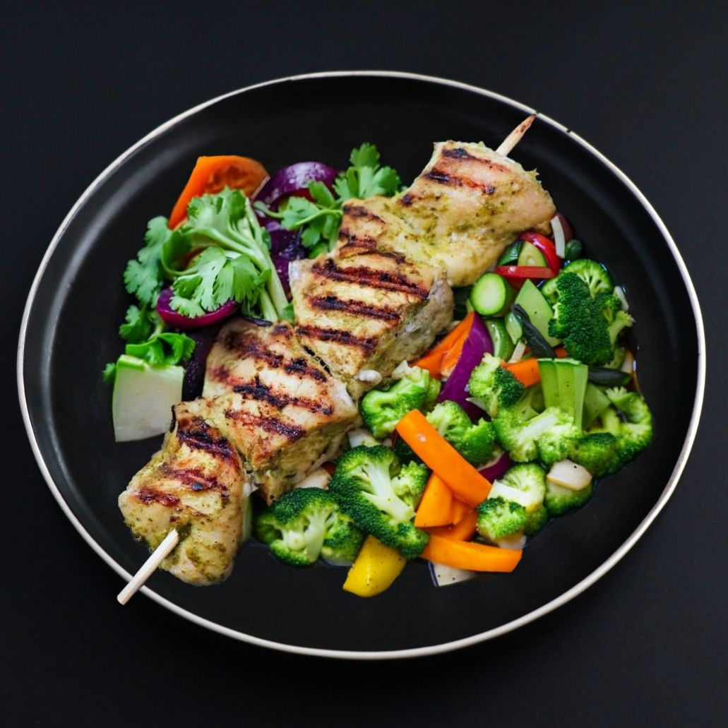 A plate containing grilled chicken souvlaki skewers with a side of mixed vegetables including broccoli and carrots.