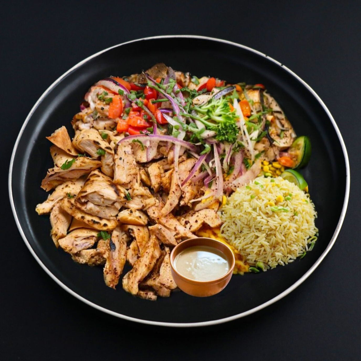 Gourmet Turkey shawarma dish is served with a side of turmeric basmati rice, herbs and steamed veggies; complemented with homemade tahini.