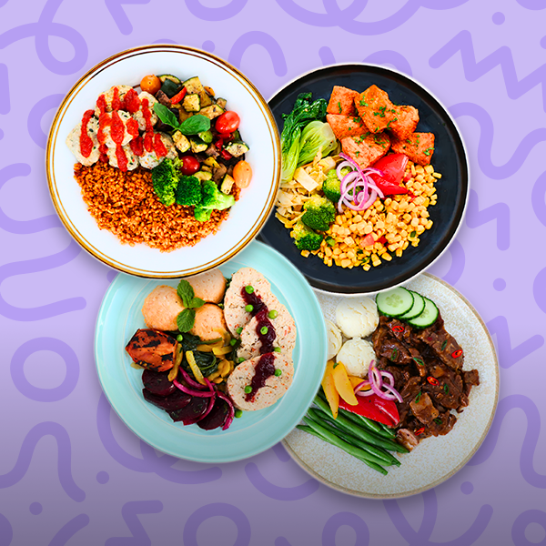 Four prepared gourmet meals arranged on a purple background, featuring salmon with vegetables and grains, sliced poultry with roasted vegetables, a hearty beef dish with green beans and root vegetables, and a grain bowl with mixed vegetables and sauce.